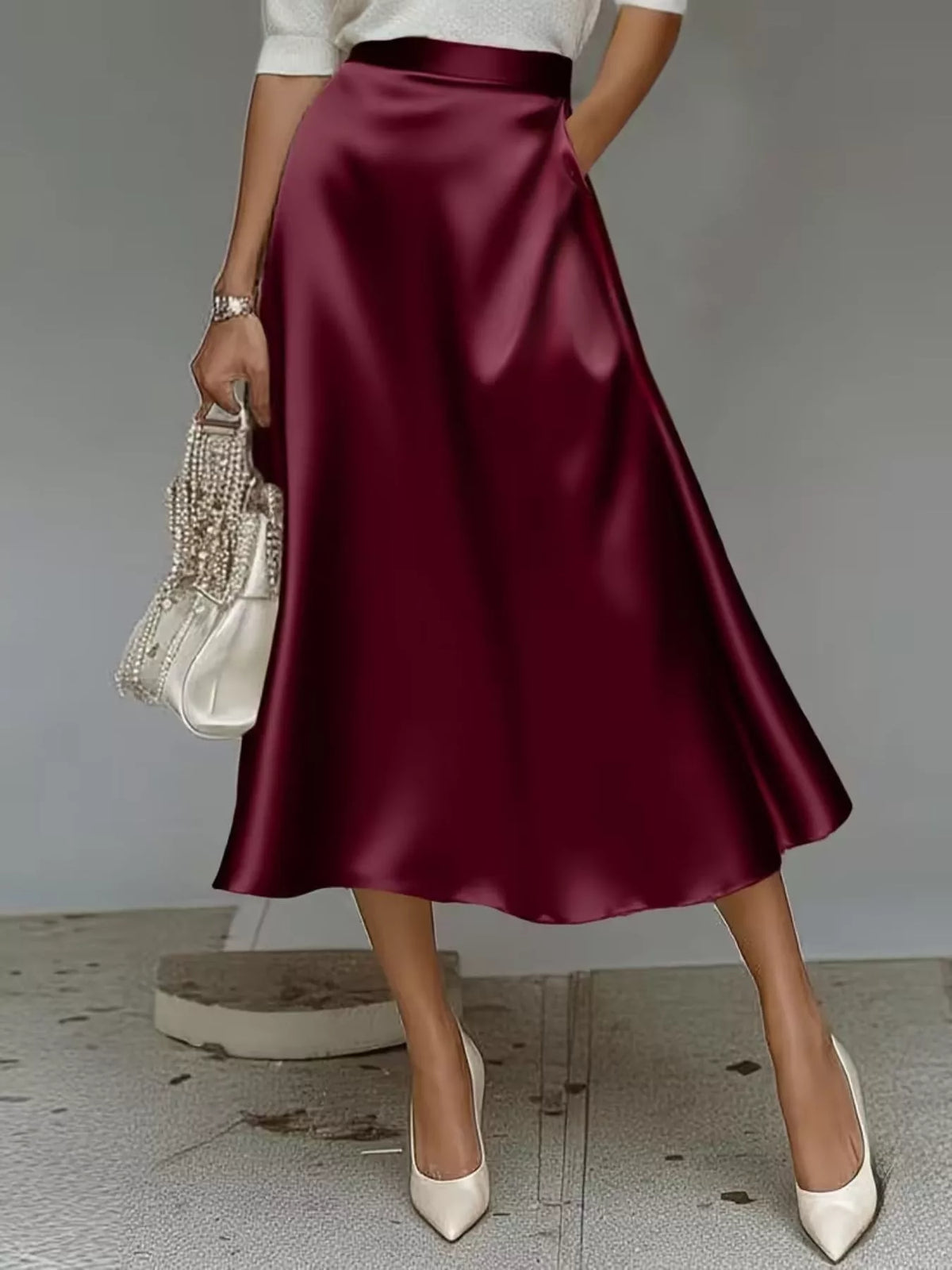 Flowing satin midi skirt with an A-line silhouette and pockets