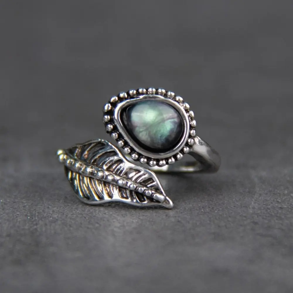 Silver-tone bypass ring with moonstone and sculpted leaf detail
